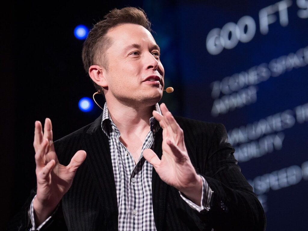 Elon Musk speaking on stage at TED